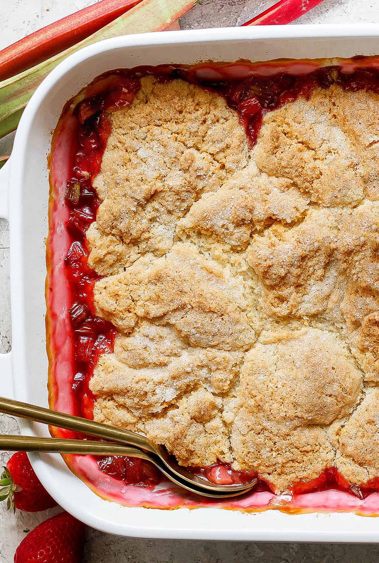 overhead photo of top of baked cobbler with strawberries and rhubarb