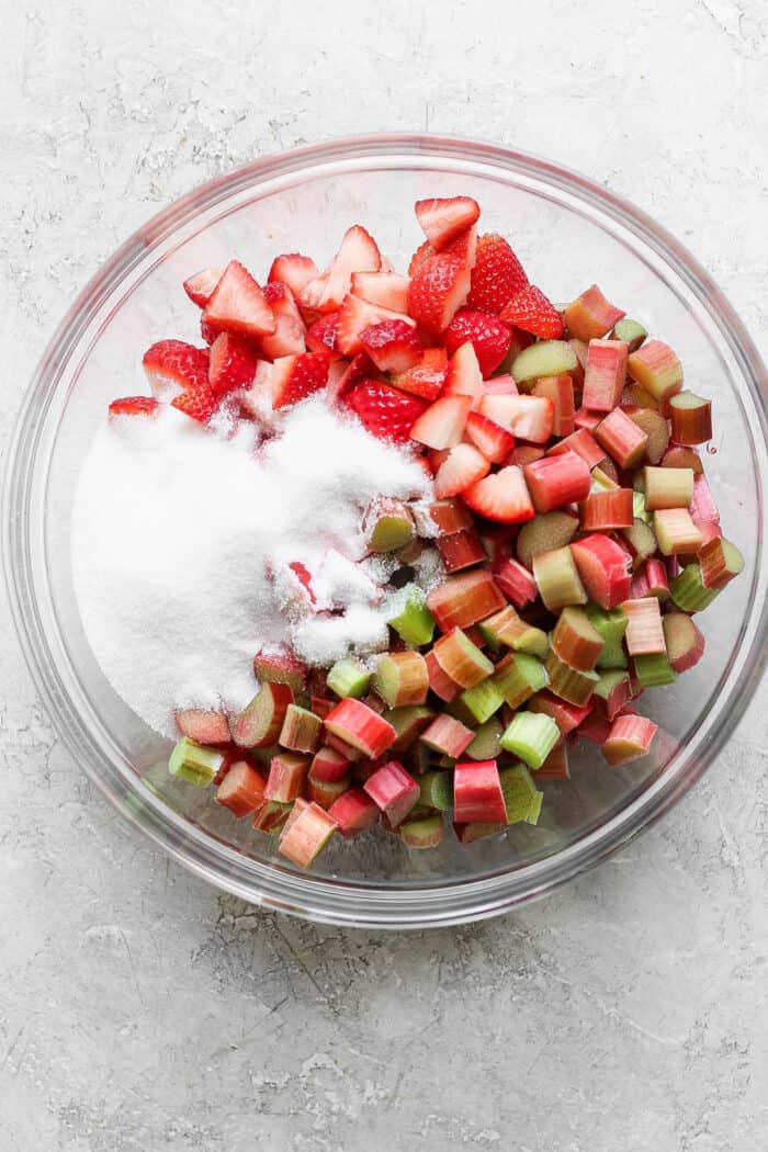 chopped rhubarb and strawberries with sugar, in a clear bowl