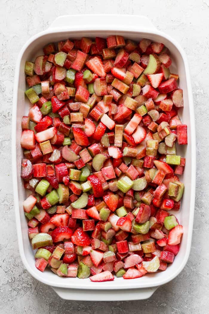 chopped rhubarb and strawberries in a white rectangular baking dish