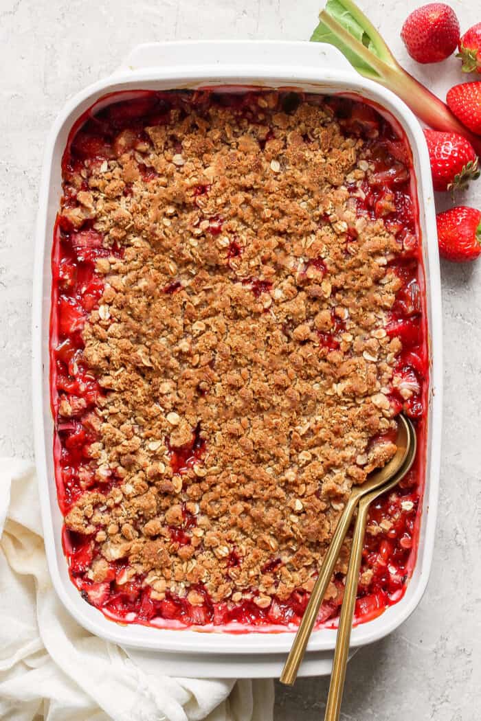 baked crisp with strawberries and rhubarb, in a white baking dish