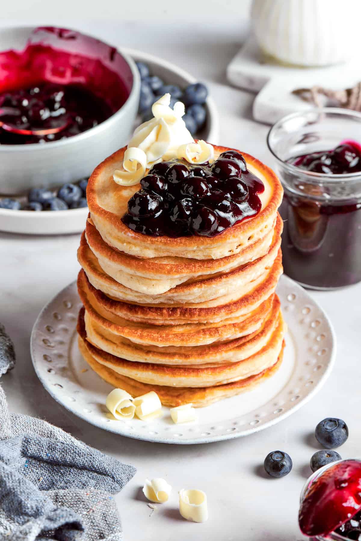 a stack of buttermilk pancakes with blueberry sauce