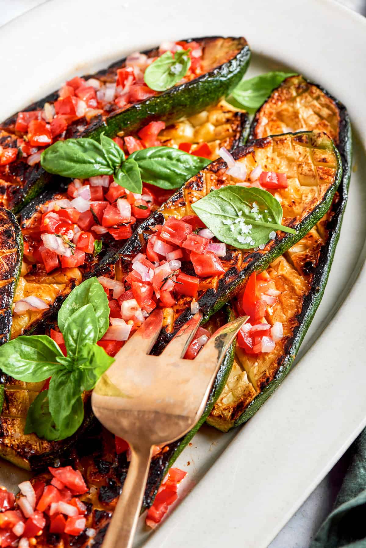 A platter of Thomas Keller zucchini with a serving fork.