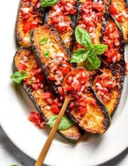 A serving utensil rests on top of a platter of Thomas Keller Zucchini.