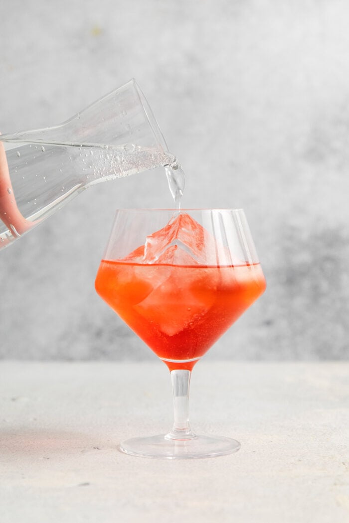 This refreshing, ruby-red Campari Spritz is a beautifully simple drink made with just 3 ingredients including campari and Prosecco. The glass is topped off with club soda.