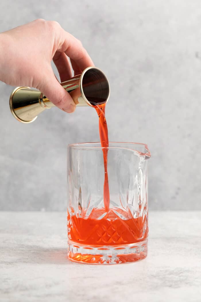 This classic Italian Negroni recipe features an easy 1-1-1 ratio of gin, Campari, and sweet vermouth and is served over ice. Campari is added to a glass.