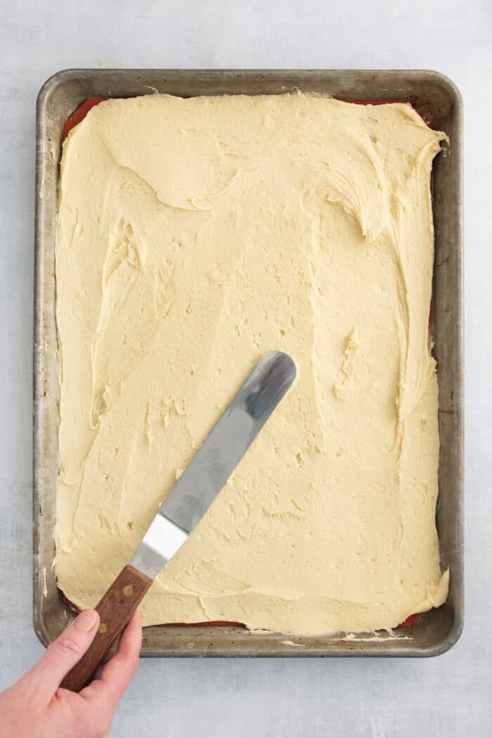 These Peach Bars feature a tender, buttery base topped with ripe, juicy peaches swirled with a touch of cinnamon. The bottom layer is spread into a pan.