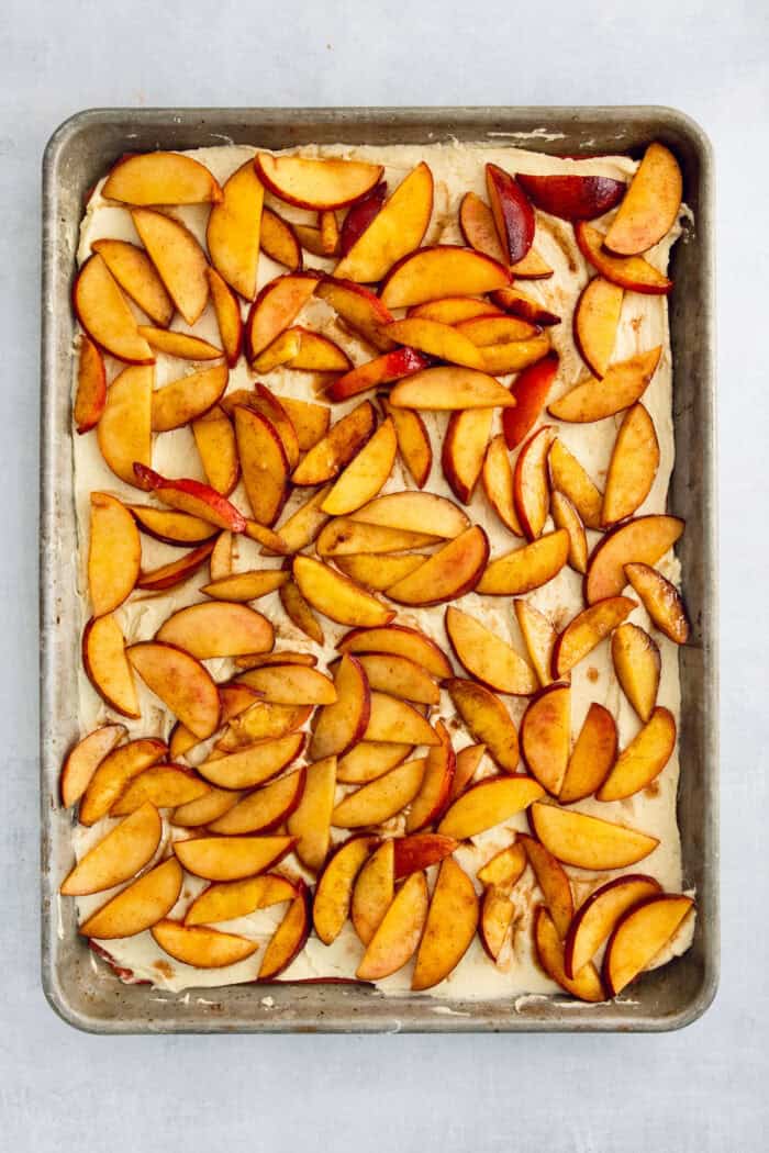 These Peach Bars feature a tender, buttery base topped with ripe, juicy peaches swirled with a touch of cinnamon. The peach filling is added to the bottom layer.