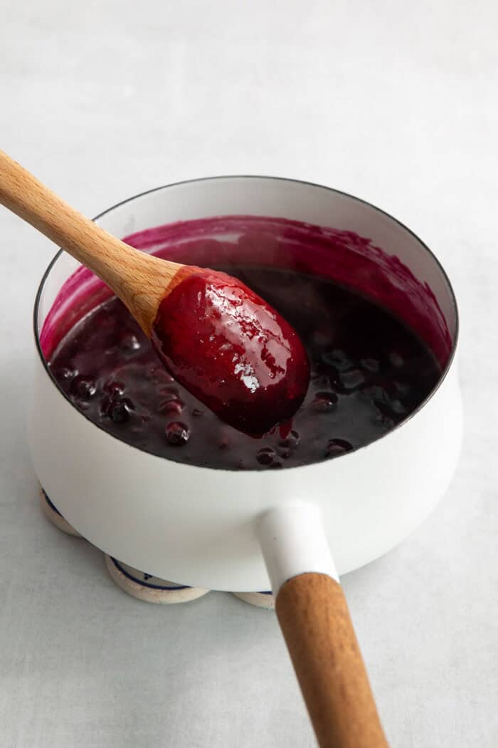 This Blueberry Butter is lightly sweet and luxuriously fluffy, with an easy homemade fresh blueberry sauce as its base. Blueberry sauce is mixed in a pot.