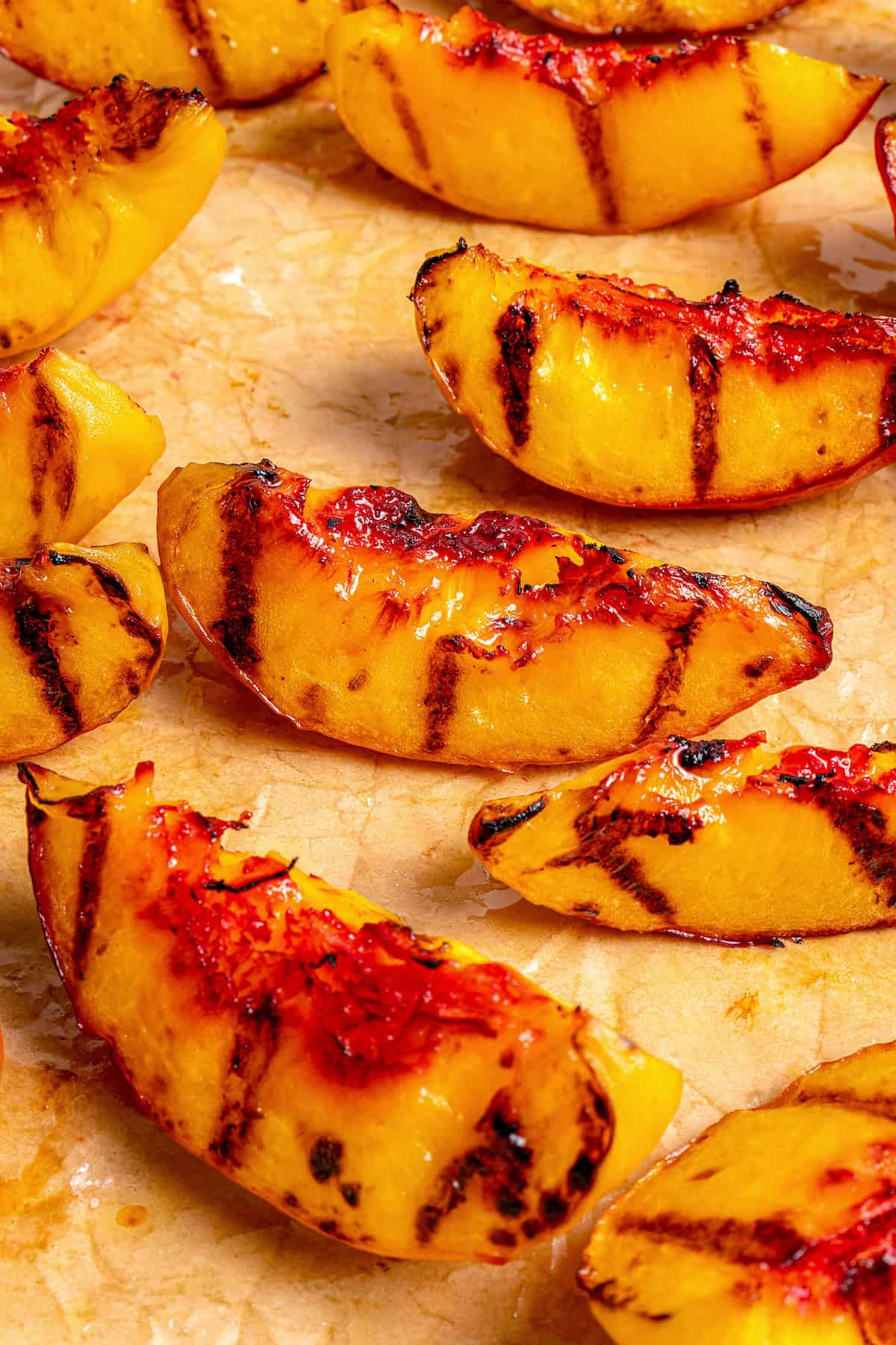 Sweet and juicy Grilled Peach Salad features lightly grilled peaches served with greens, cherry tomatoes, and fresh mozzarella. Slightly charred slices of grilled peach.