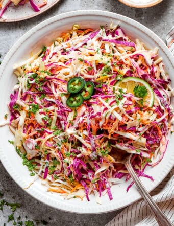 coleslaw with jalapeno and lime in a white bowl