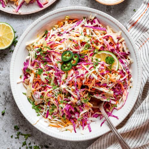 coleslaw with jalapeno and lime in a white bowl