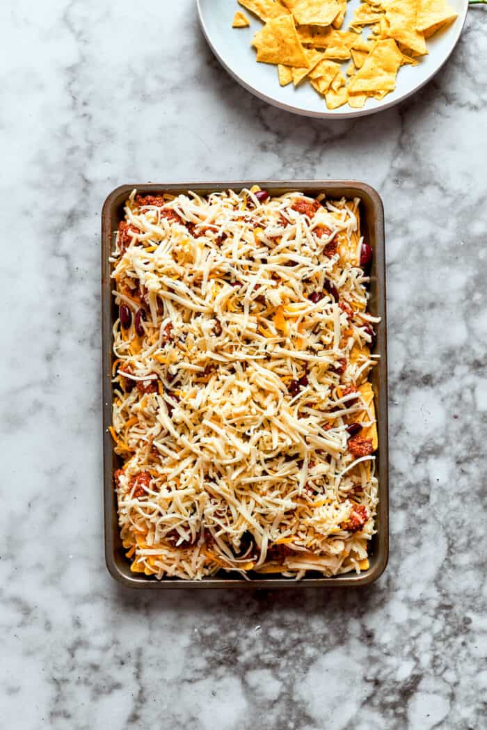 This Macho Nachos recipe features layers of crispy tortilla chips, melty cheese, and seasoned beef. Perfect for any casual gathering! Shredded cheese is added as the final layer.