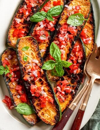 overhead photo of seared and roasted zucchini with fresh tomato sauce