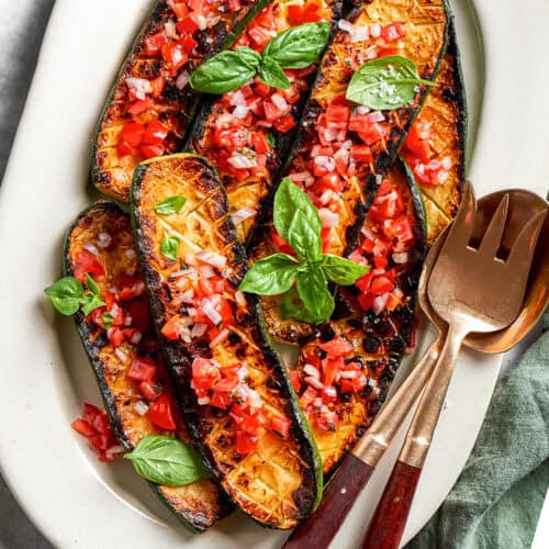 overhead photo of seared and roasted zucchini with fresh tomato sauce