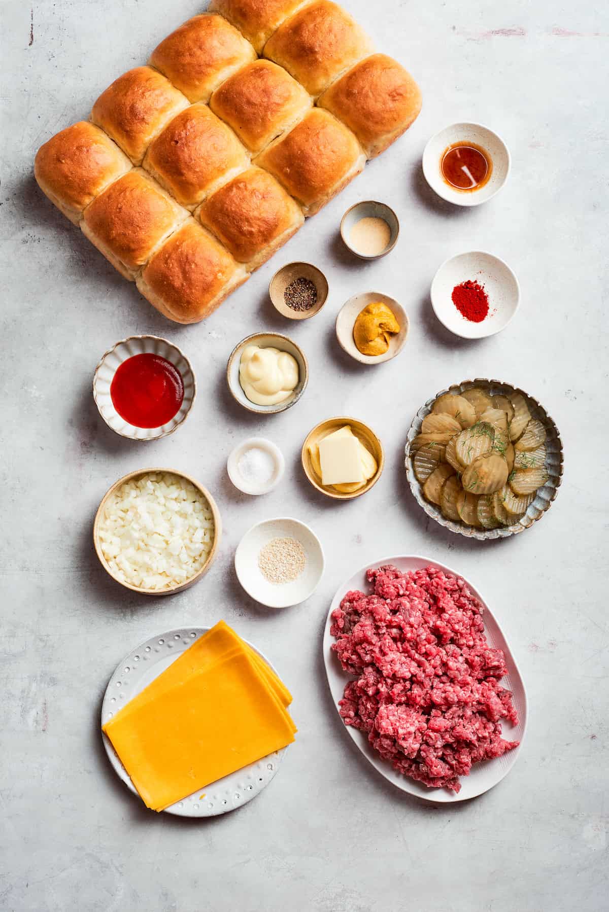 Homemade Cheeseburger Sliders star tender ground beef topped with plenty of melted cheddar cheese served on sweet rolls. Ingredients for cheeseburger sliders include ground beef, roll, cheese, ketchup, mustard, mayonnaise, Worcestershire sauce, salt and pepper, pickles.