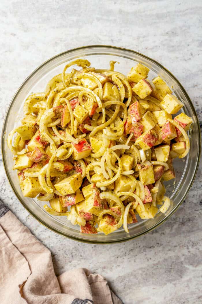 Savory Grilled Potato Packets feature grilled potatoes in foil dressed in tangy, garlicky pesto-ranch sauce and ready in less than 30 minutes. The mix for grilled potato packets in a bowl.