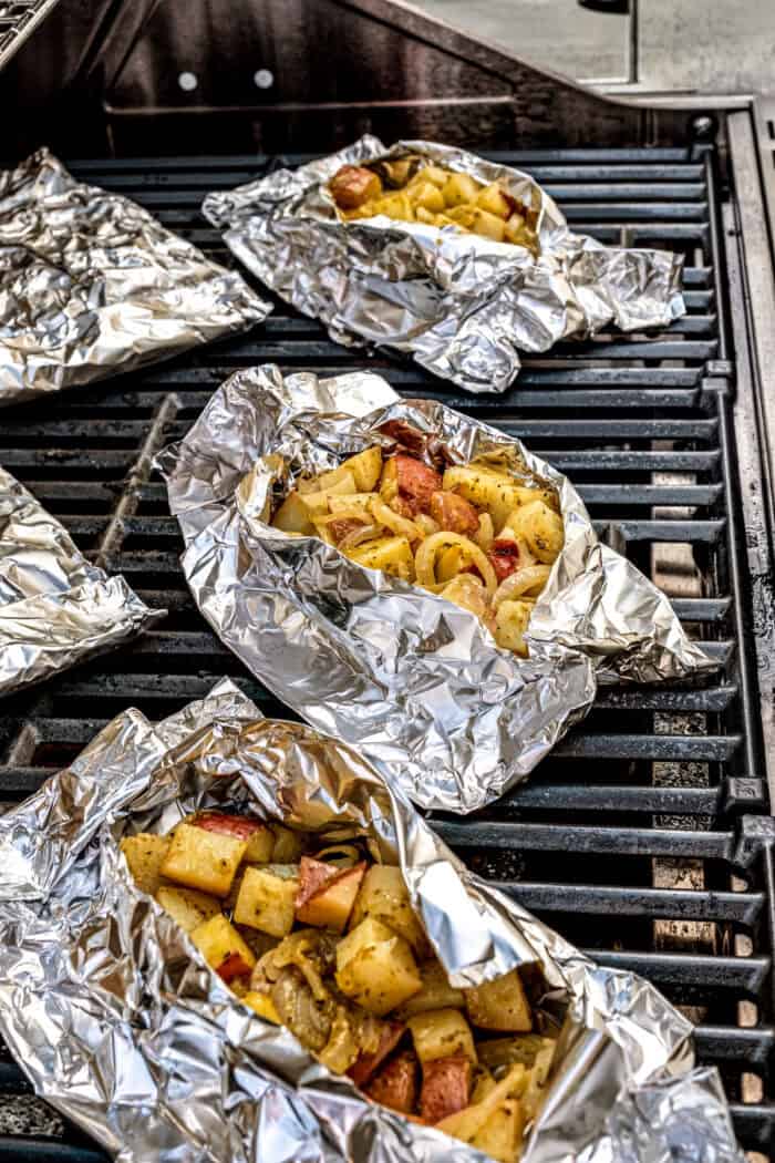Savory Grilled Potato Packets feature grilled potatoes in foil dressed in tangy, garlicky pesto-ranch sauce and ready in less than 30 minutes. Potatoes wrapped in foil cook on the grill.