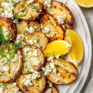 grilled potato slices topped with dill, feta, and fresh lemon