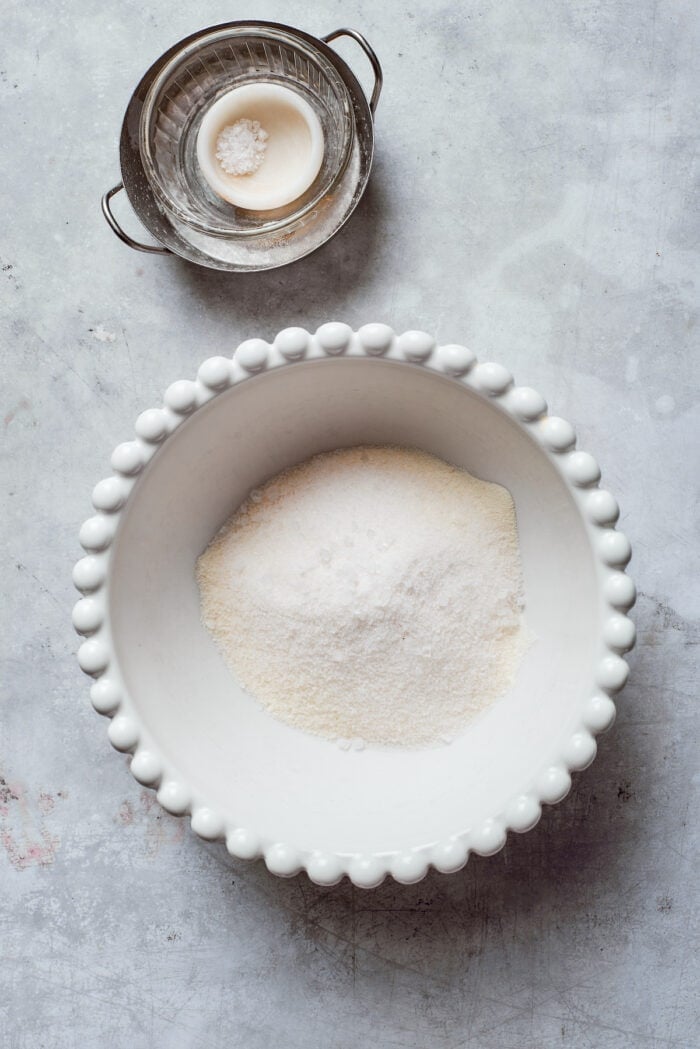 Rømmegrøt is a warmed Norwegian porridge similar to rich pudding, served with a drizzle of melted butter and a good sprinkling of cinnamon! Flour and sugar are mixed in a bowl.