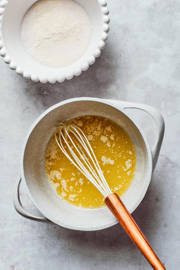 Rømmegrøt is a warmed Norwegian porridge similar to rich pudding, served with a drizzle of melted butter and a good sprinkling of cinnamon! Melted butter is whisked in a pot.