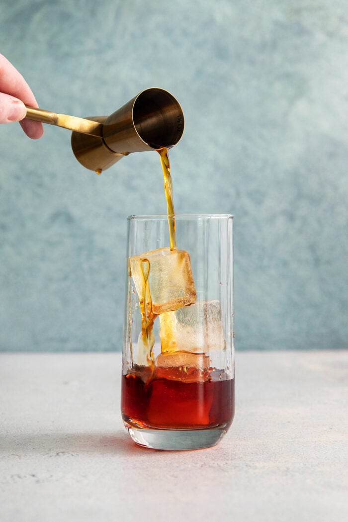 This 3-ingredient Americano Cocktail is made from equal parts Campari and sweet vermouth plus a splash of bubbly club soda. Sweet vermouth is added to a glass of Americano cocktail.