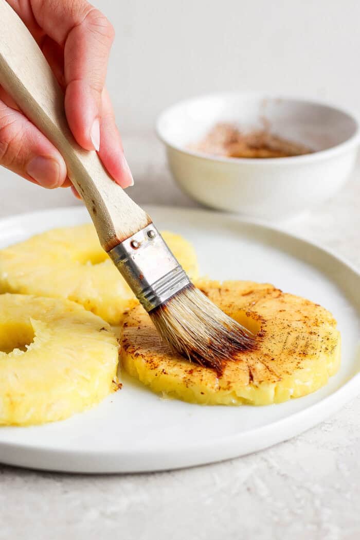 Lightly caramelized and so juicy Grilled Pineapple is a blend of sweet and spicy, perfect on top of burgers or as a dessert. A pastry brush brushes pineapple with marinade.