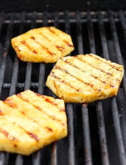 Slices of pineapple cool on the grill.