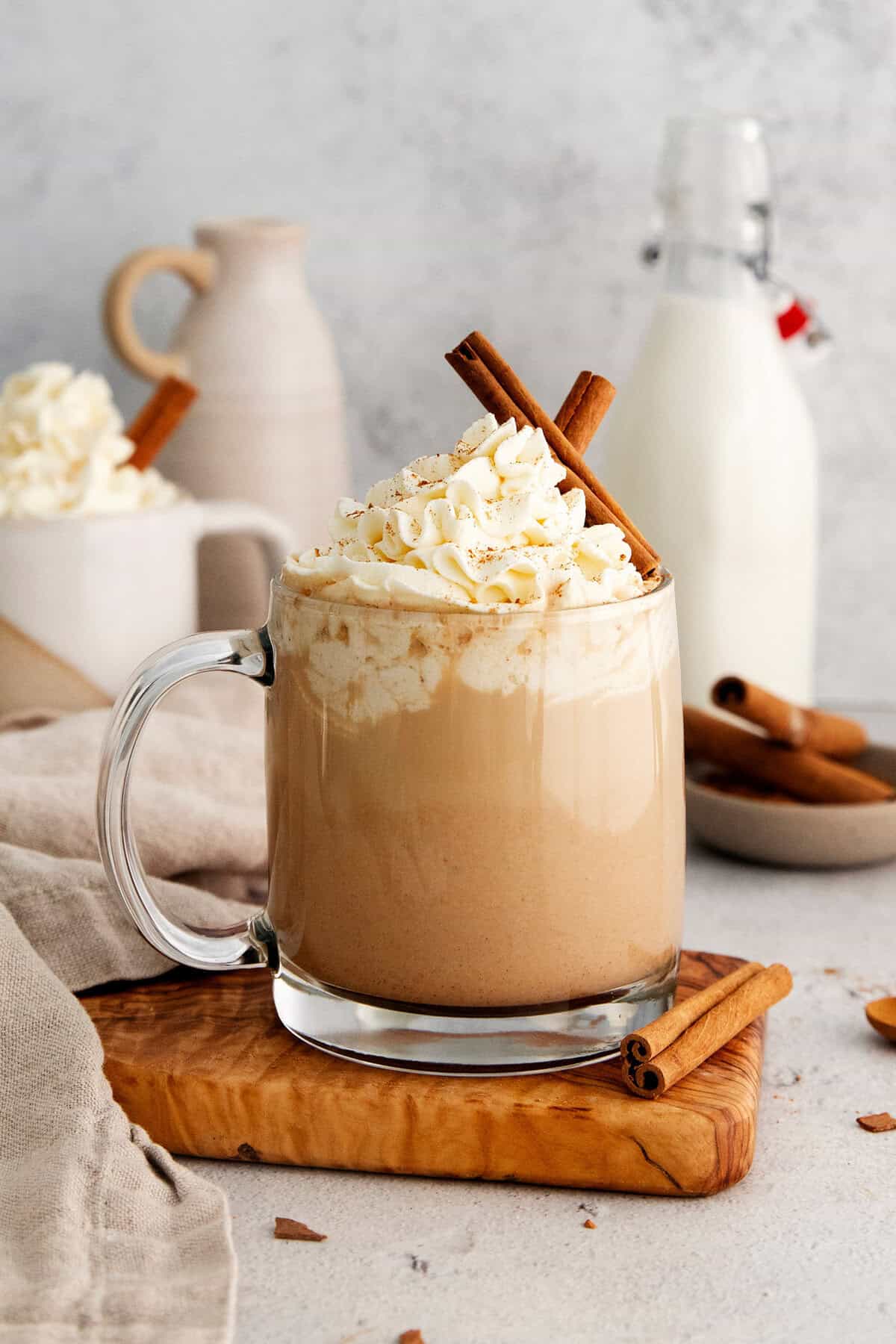 This Pumpkin Spice Latte has a base of pumpkin sauce sweetened with maple sugar that's mixed with strong espresso and topped with frothy milk. Mugs of pumpkin spice latte are garnished with cinnamon sticks and topped with whipped cream.
