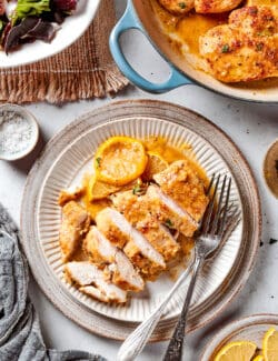 a sliced chicken breast with lemon and pepper, on a plate
