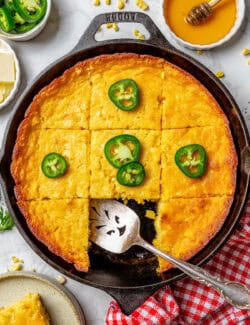overhead photo of Jiffy corn casserole in a cast iron pan, cut into pieces