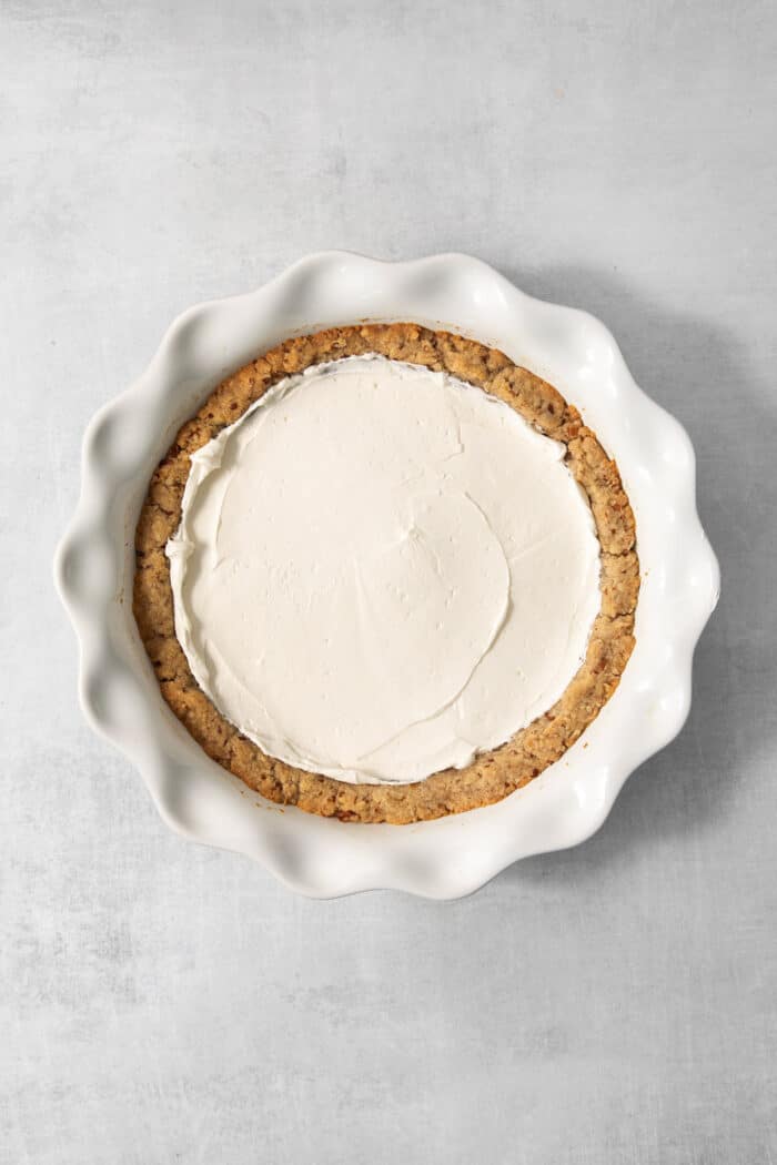 This chilled possum pie recipe with three layers of chocolate, cream cheese, and whipped cream goodness will be your new favorite dessert. Spreading the cream cheese layer in the pie.