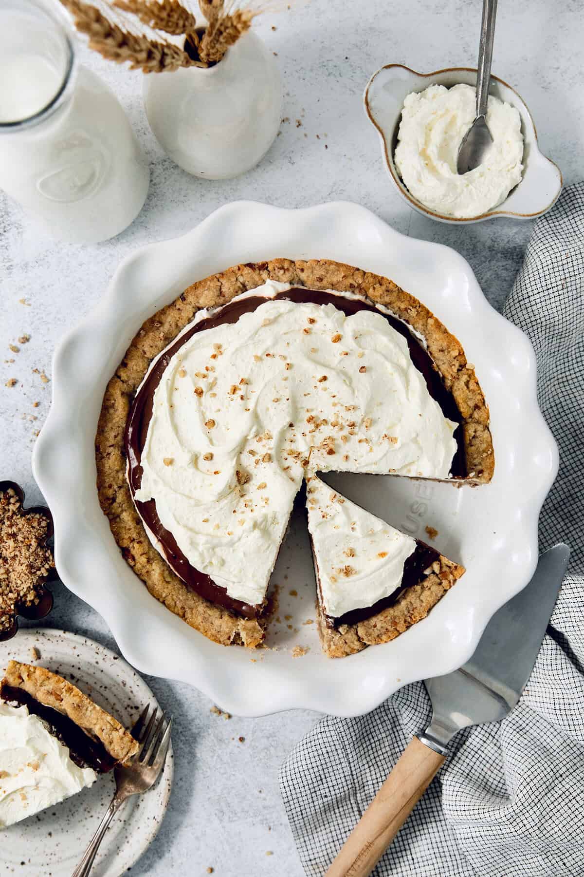This chilled possum pie recipe with three layers of chocolate, cream cheese, and whipped cream goodness will be your new favorite dessert. Overhead shot of homemade possum pie with fluffy whipped cream on top.