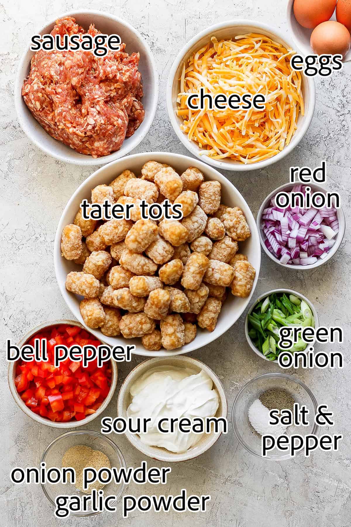 This garlicky tater tot breakfast casserole recipe with red peppers, onions, and sausage is an effortless morning bite. Labeled ingredients for making tater tot breakfast casserole.