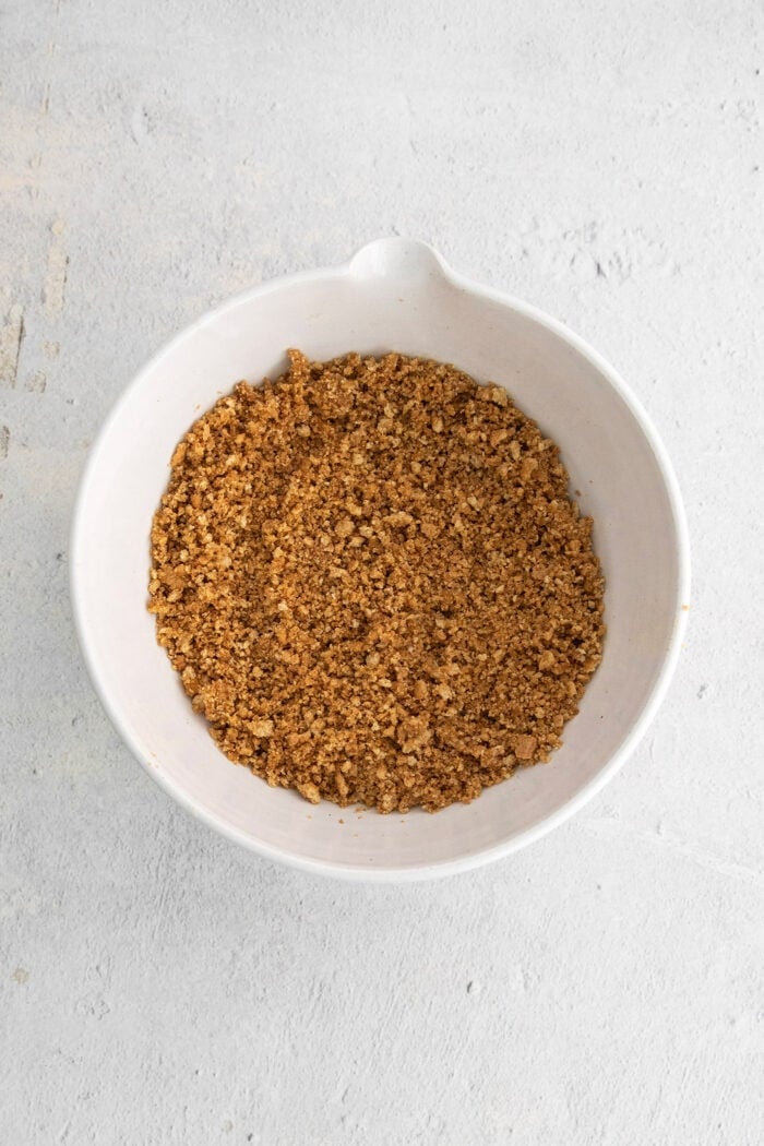 graham cracker crumbs for the crust, in a white mixing bowl