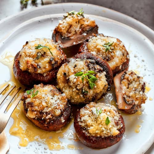 mushrooms stuffed with cheese and breadcrumbs on a plate