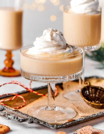 festive glasses of eggnog with twinkly lights in background