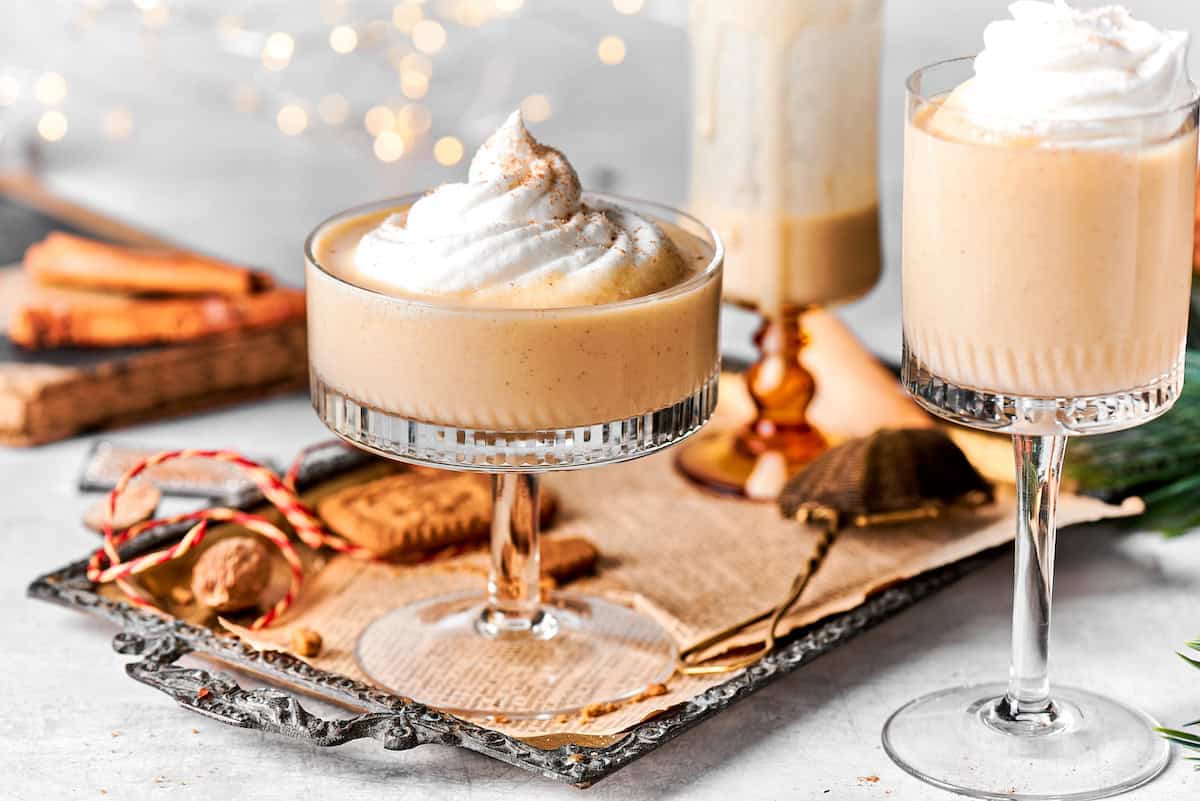 festive glasses of eggnog with twinkly lights in background