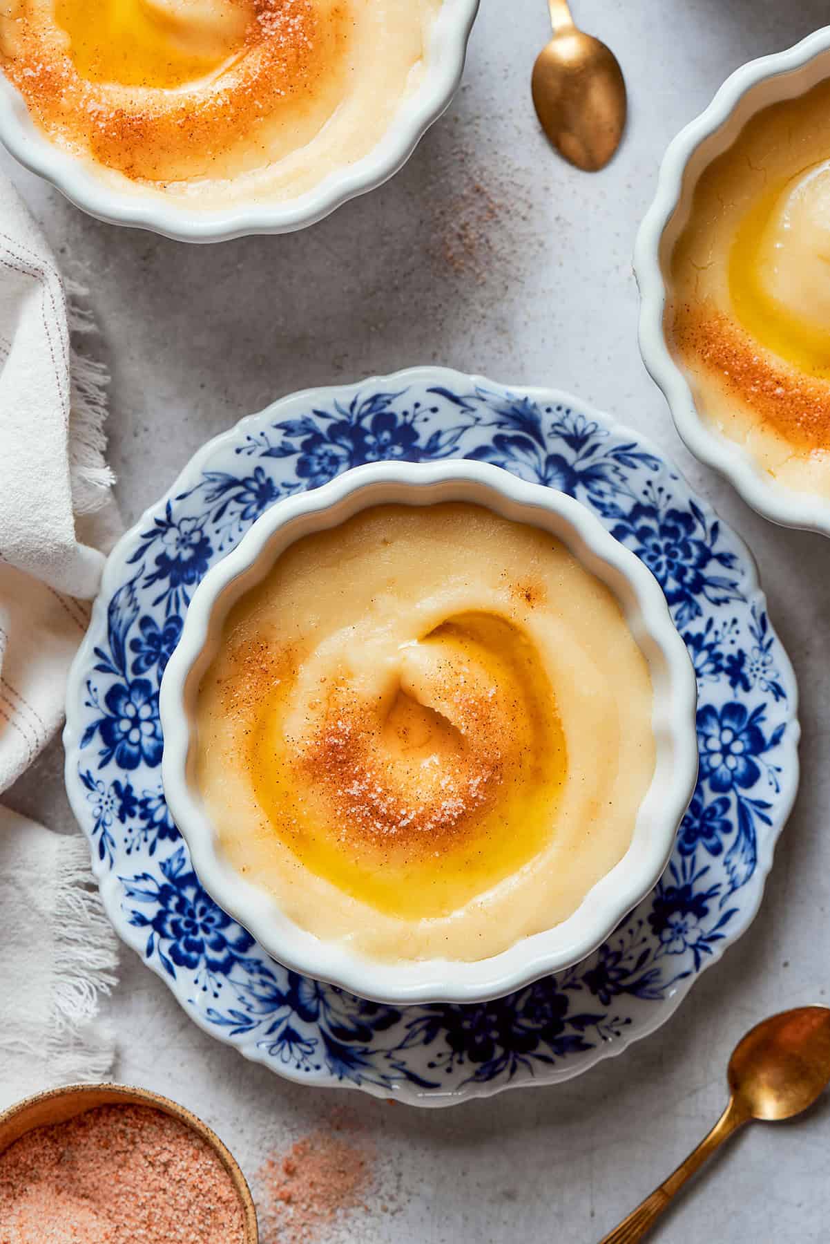 Rømmegrøt is a warmed Norwegian porridge similar to rich pudding, served with a drizzle of melted butter and a good sprinkling of cinnamon! Norwegian rommegrot in a white bowl, with cinnamon-sugar and melted butter
