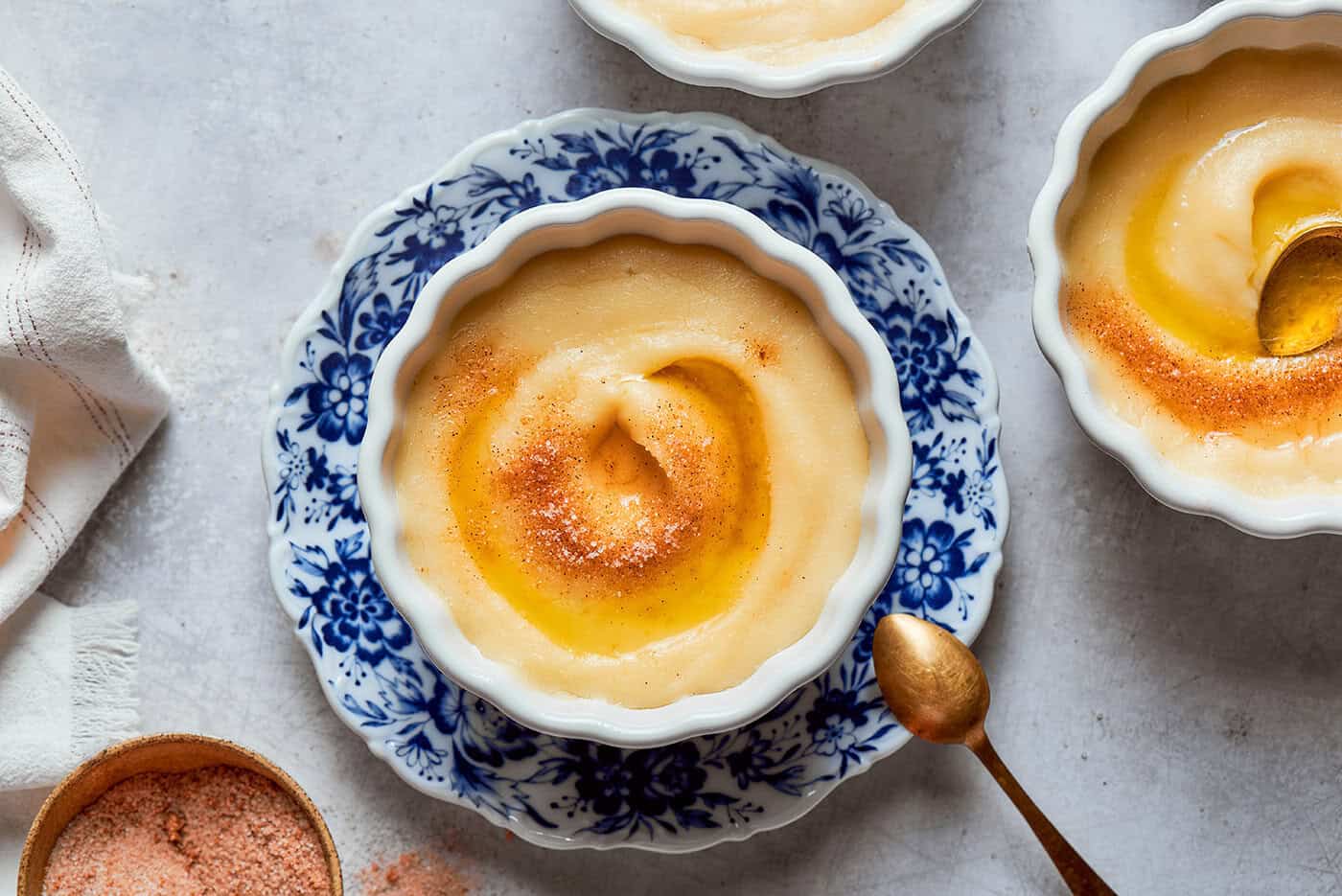 Norwegian rommegrot in a white bowl, with cinnamon-sugar and melted butter