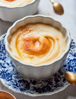 Norwegian rommegrot in a white bowl, with cinnamon-sugar and melted butter