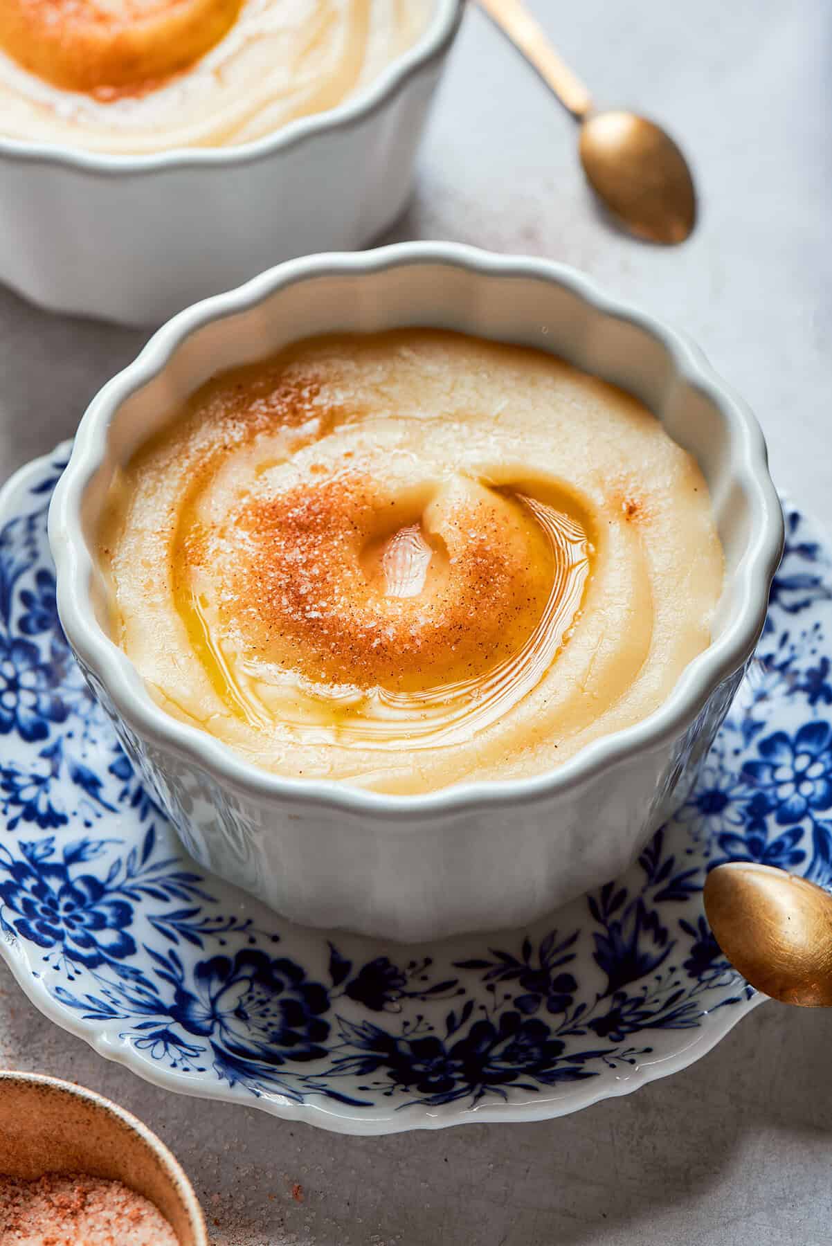 Norwegian rommegrot in a white bowl, with cinnamon-sugar and melted butter