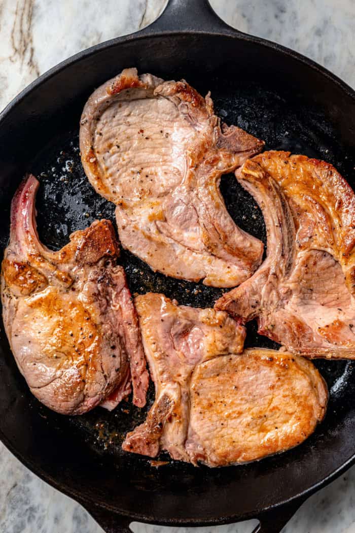 seared pork chops in a cast iron skillet