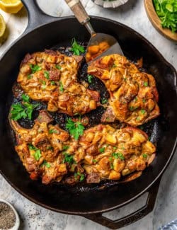 pork chops with stuffing and gravy in a cast iron skillet