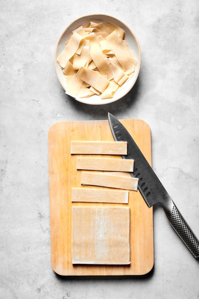 These easy homemade wonton chips have the most fantastic crunch and a salty flavor that makes them pair with just about anything! Overhead view of wonton wrappers being cut into strips