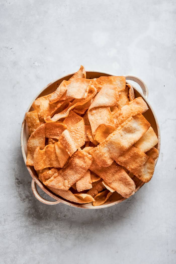 These easy homemade wonton chips have the most fantastic crunch and a salty flavor that makes them pair with just about anything! Overhead view of wonton chips in bowl