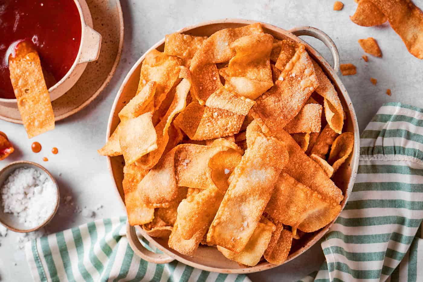 These easy homemade wonton chips have the most fantastic crunch and a salty flavor that makes them pair with just about anything! a bowl of homemade wonton chips with dipping sauce