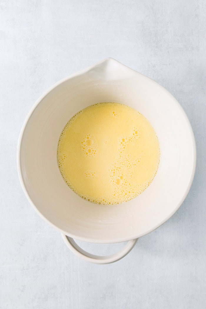 This Colombian Pandebono recipe is fantastically cheesy, surprisingly easy, and irresistibly tender and fluffy. So delicious! Liquid ingredients for pandebono in mixing bowl
