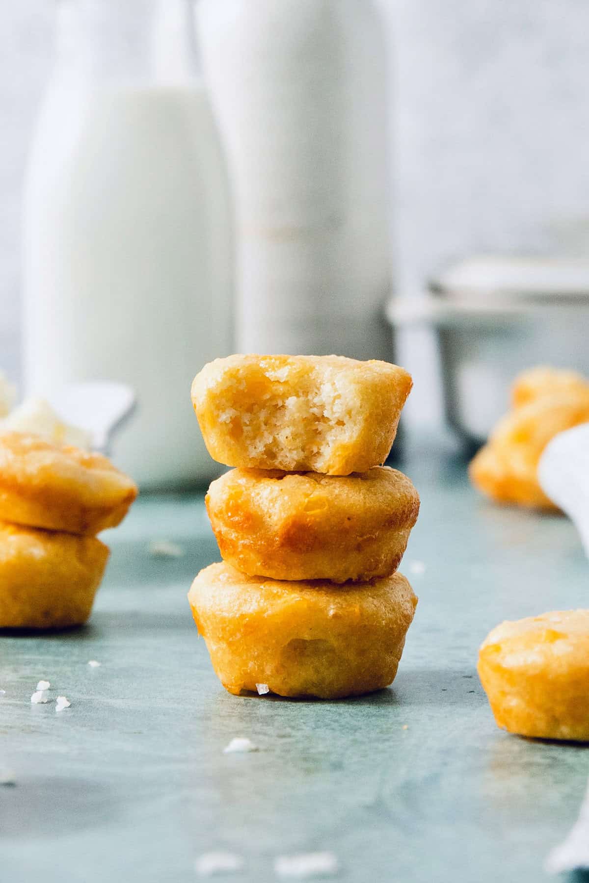 This Colombian Pandebono recipe is fantastically cheesy, surprisingly easy, and irresistibly tender and fluffy. So delicious! Stack of 3 pandebono, with top one bitten into to show texture inside