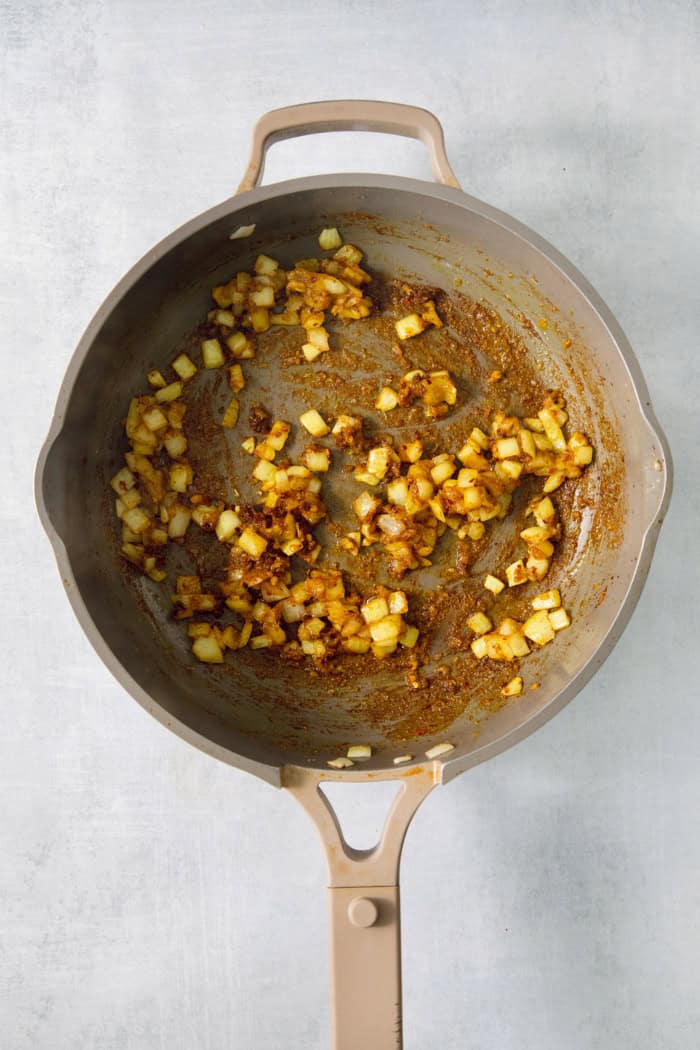 This easy Shrimp Curry recipe combines elements of Thai and Indian curries for a uniquely delicious weeknight meal. So quick and easy! Aromatics cooking in saucepan