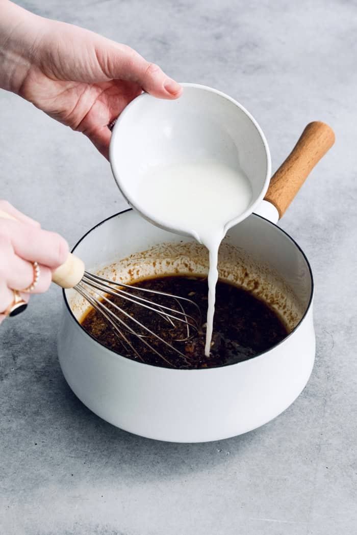 Pouring cornstarch slurry into pan of teriyaki sauce